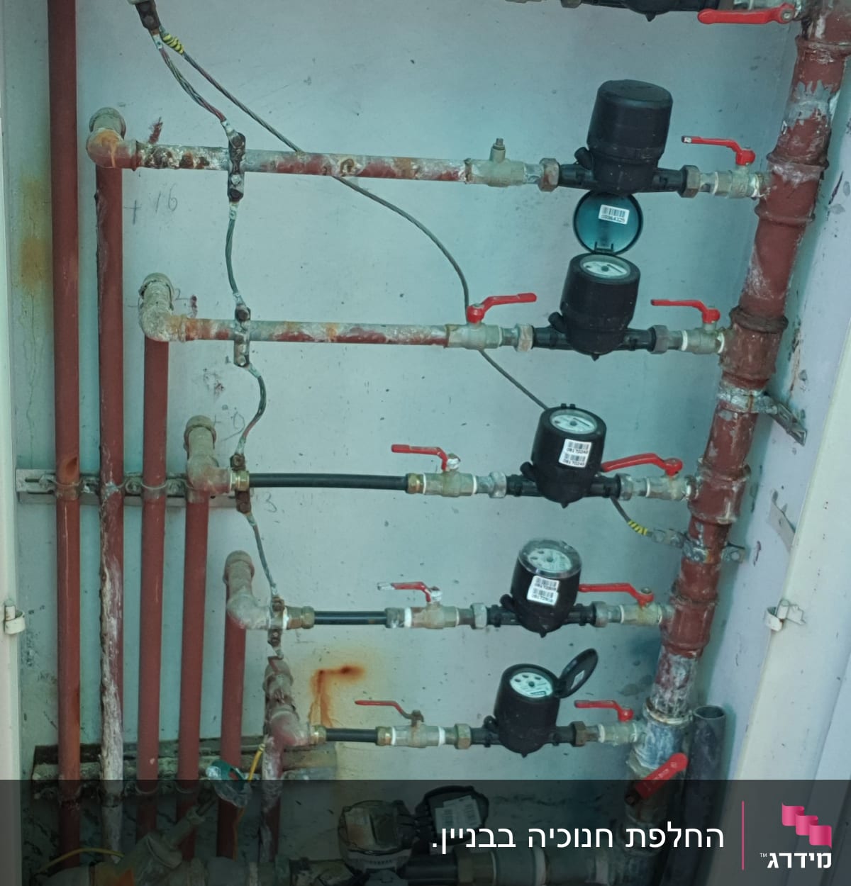 צינורות מים עם ברזים ומדי מים בארון פתוח